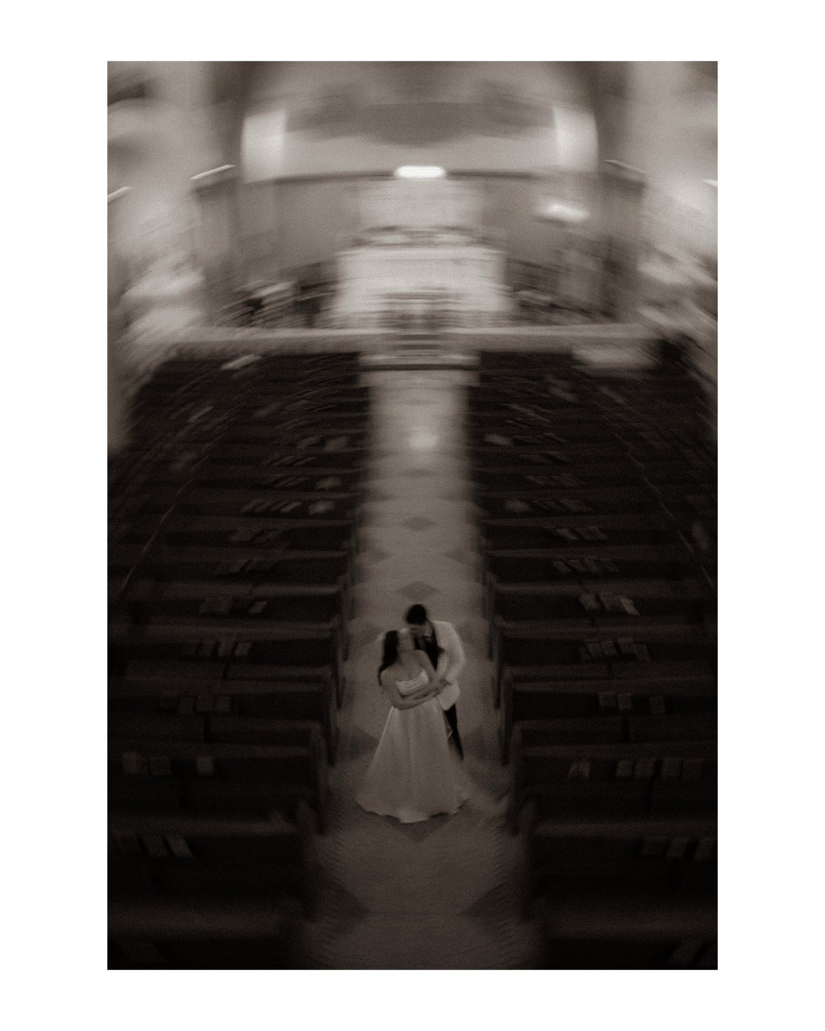 Artistic black and white wedding photo in grand church interior.