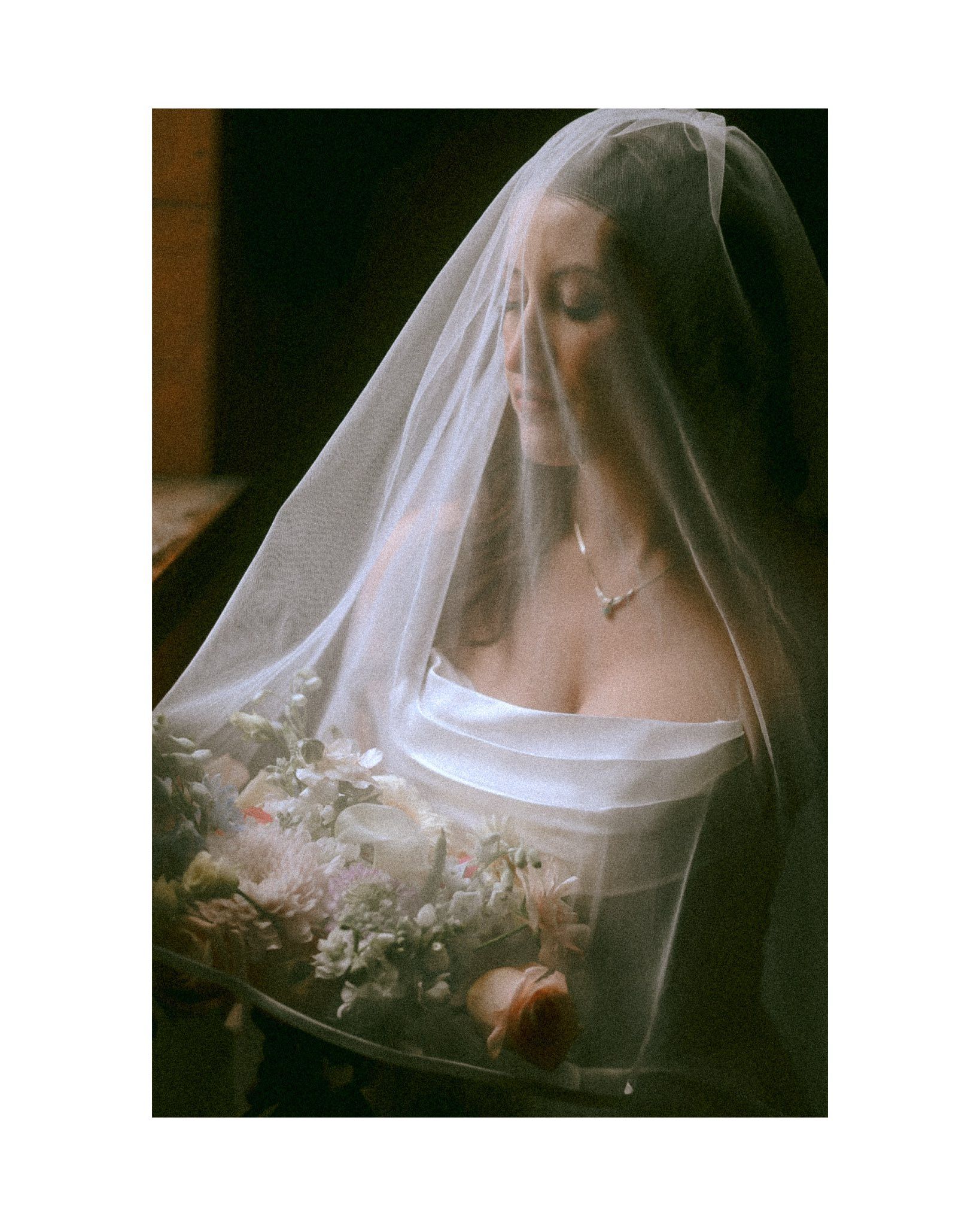 Ethereal bridal portrait with delicate veil and white dress.