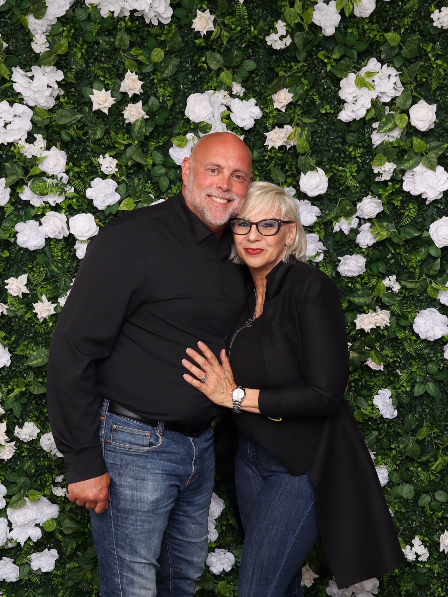 Collage of a couple posing together against a white floral backdrop.