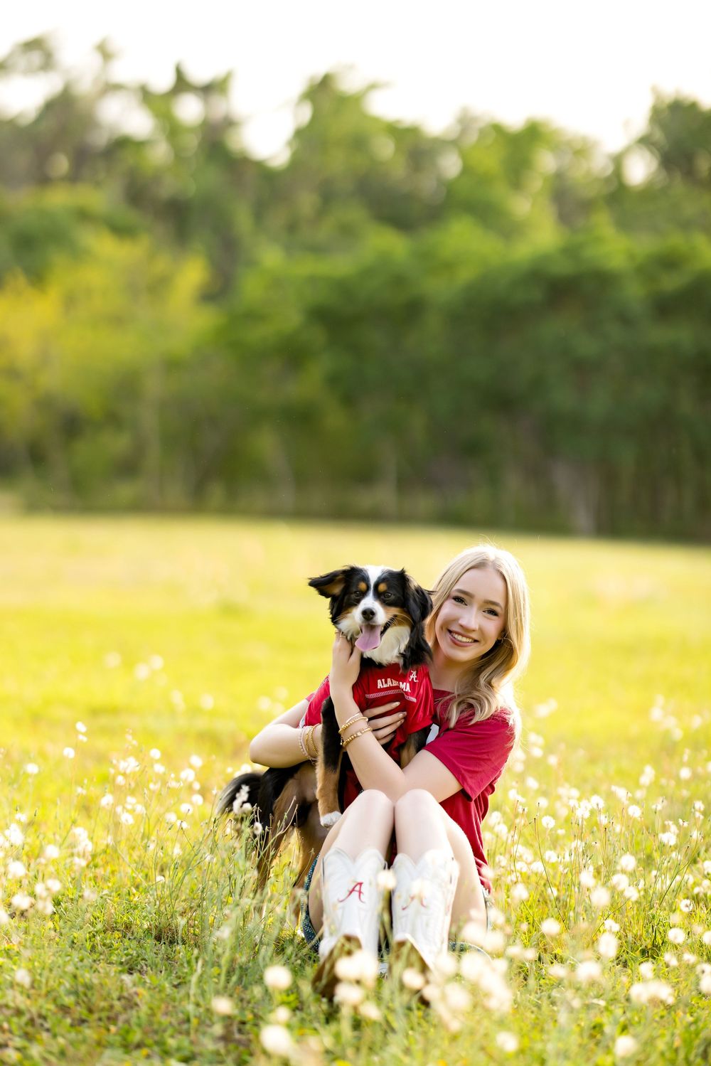 Tender moment captured in a wildflower meadow with a black and white dog wearing a red shirt.