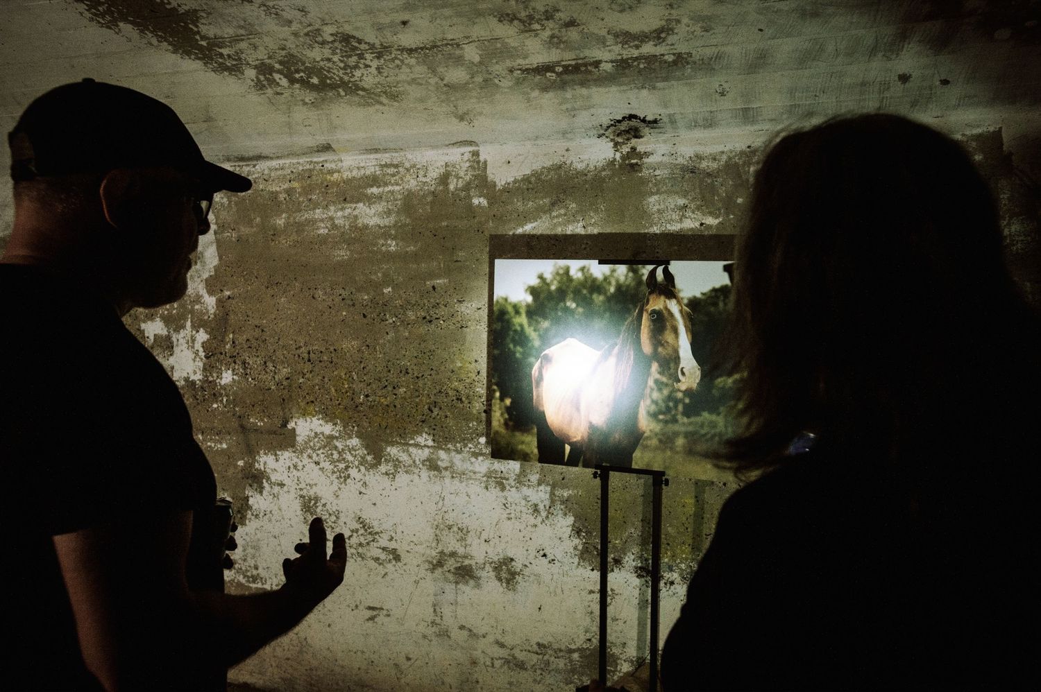 A sequence of dark tunnel images showing flashlight beams illuminating rough stone walls in an underground passage.