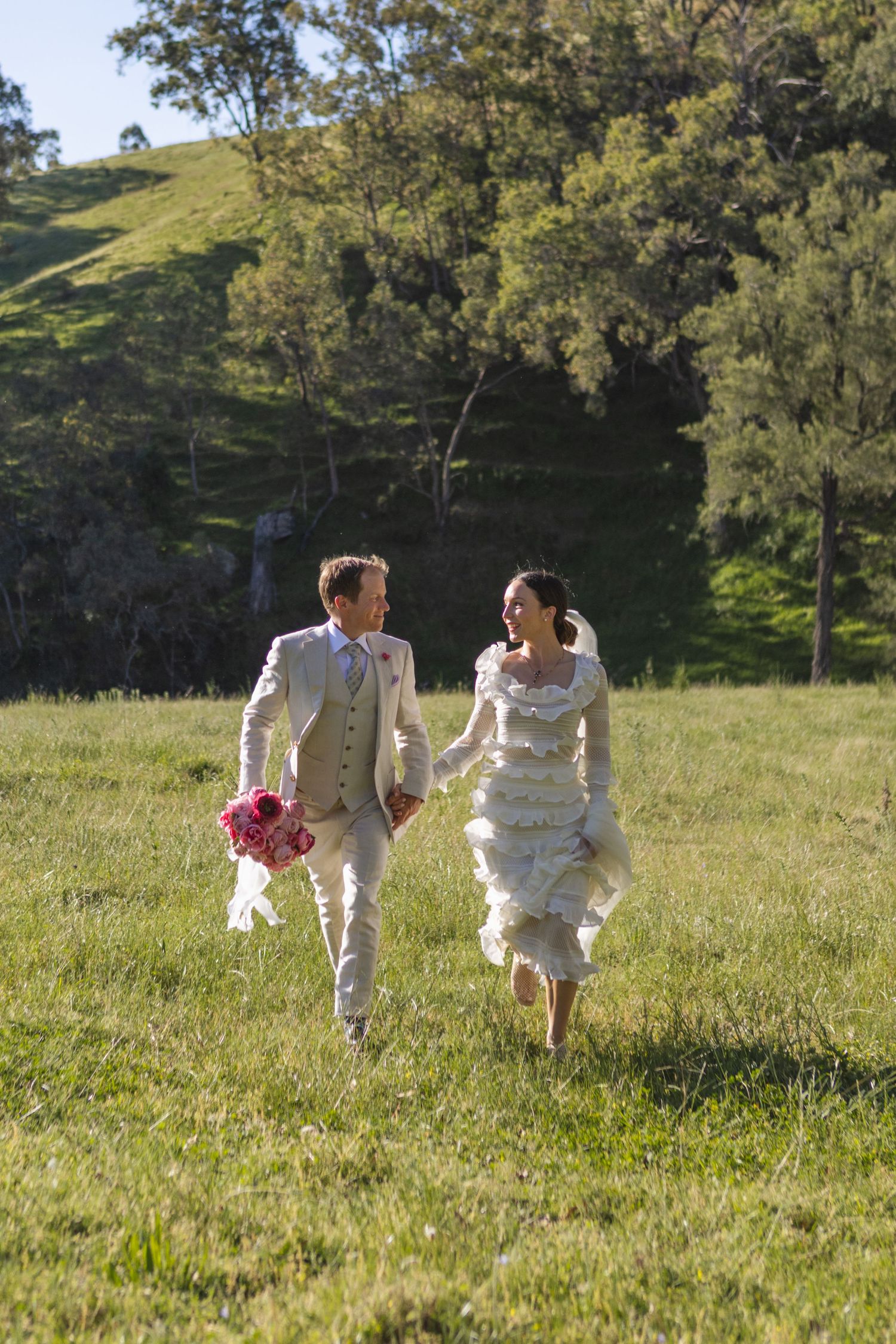 Bride and groom running through paddock at Scone NSW Country wedding