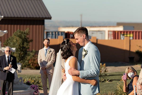 Bride and groom celebrating joyfully outside with guests during sunny Eastern Washington wedding