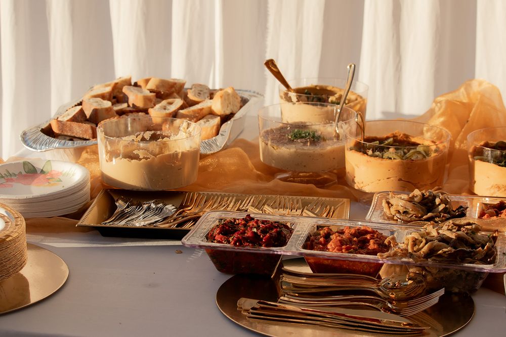 Table filled with bread, dips, and snacks for a rustic wedding reception spread