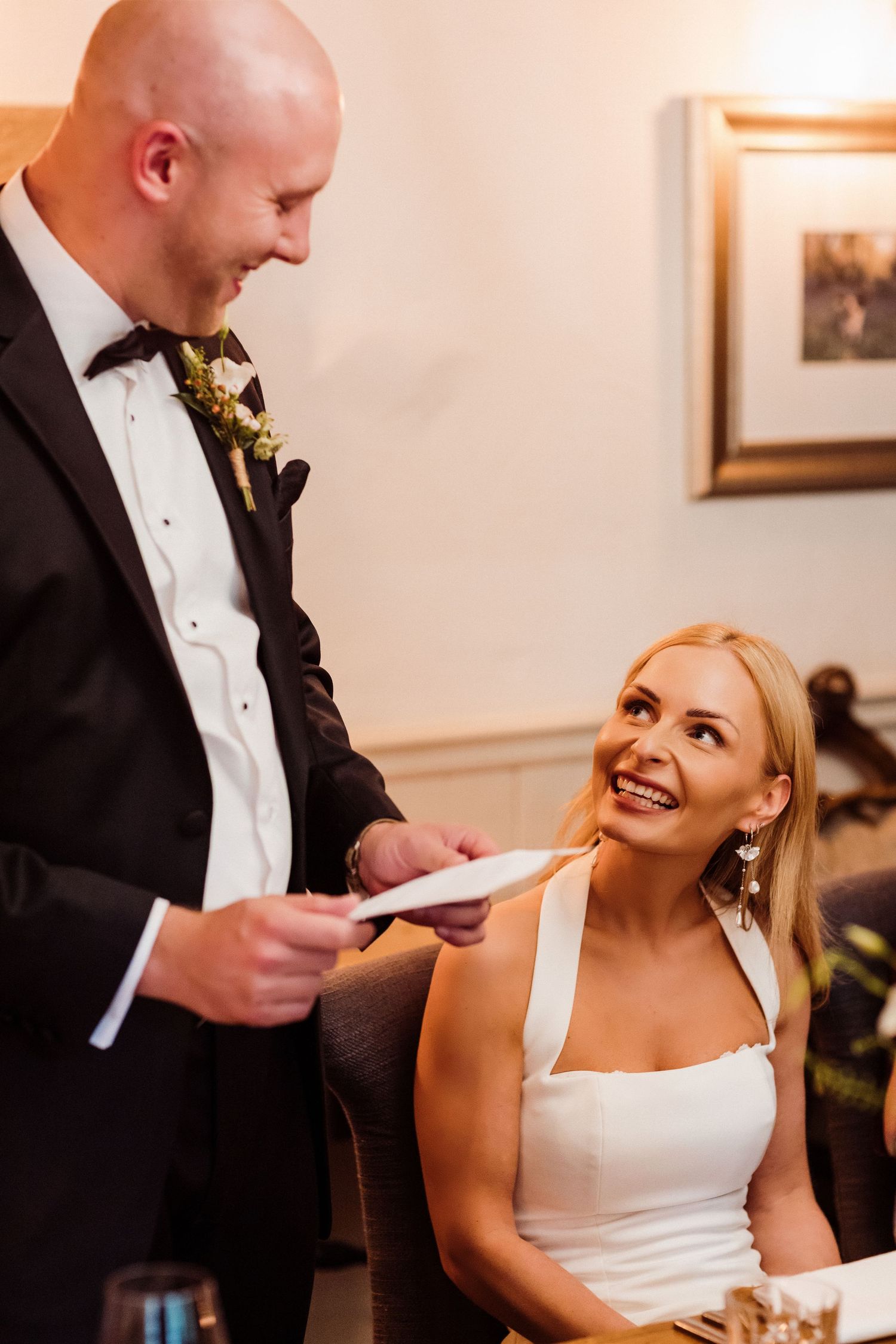 A joyful couple shares a candid moment during their wedding reception at an indoor venue.