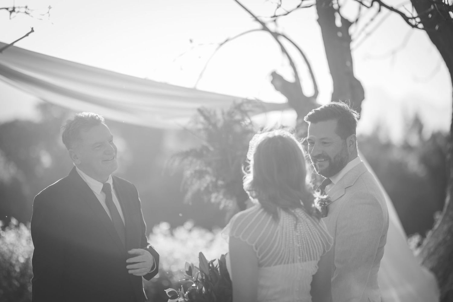 A black and white photo montage showing multiple wedding celebration scenes with people dancing and embracing outdoors.
