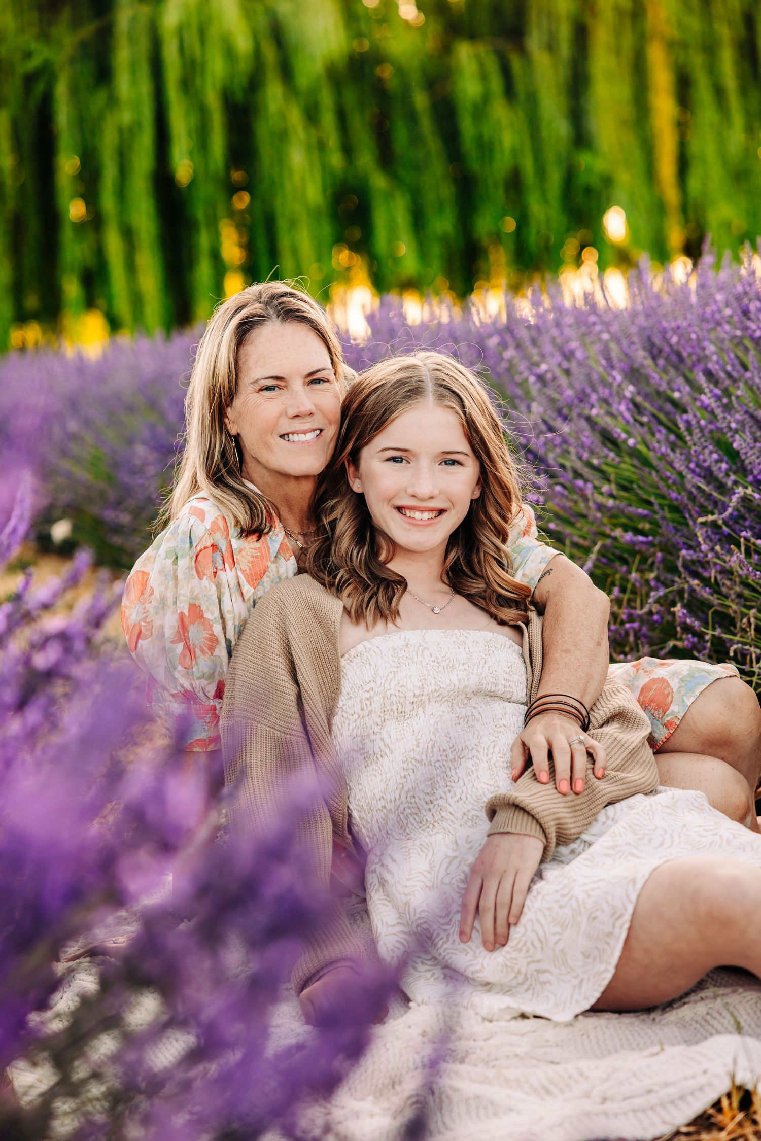 Two people pose together in a blooming lavender field during a summer photo session.