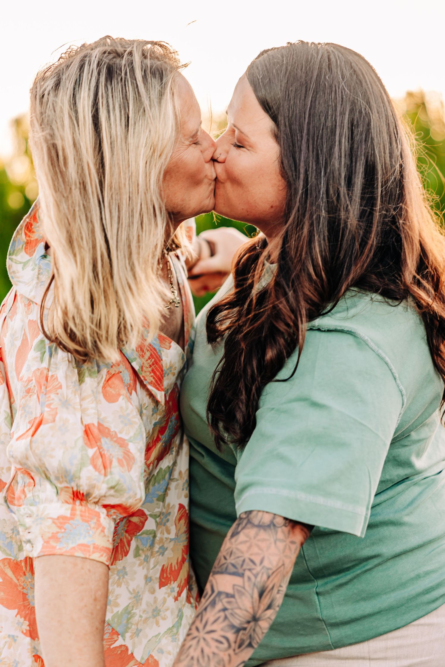 Four romantic photos showing couples sharing tender kisses outdoors in coordinated green and floral outfits.