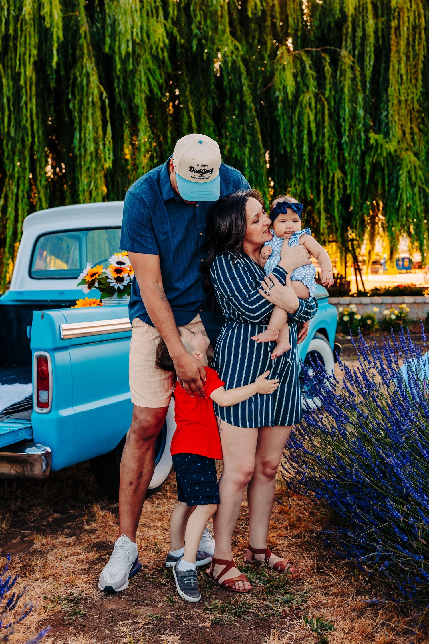 A vintage blue pickup truck parked near blooming lavender bushes creates a dreamy summer scene.