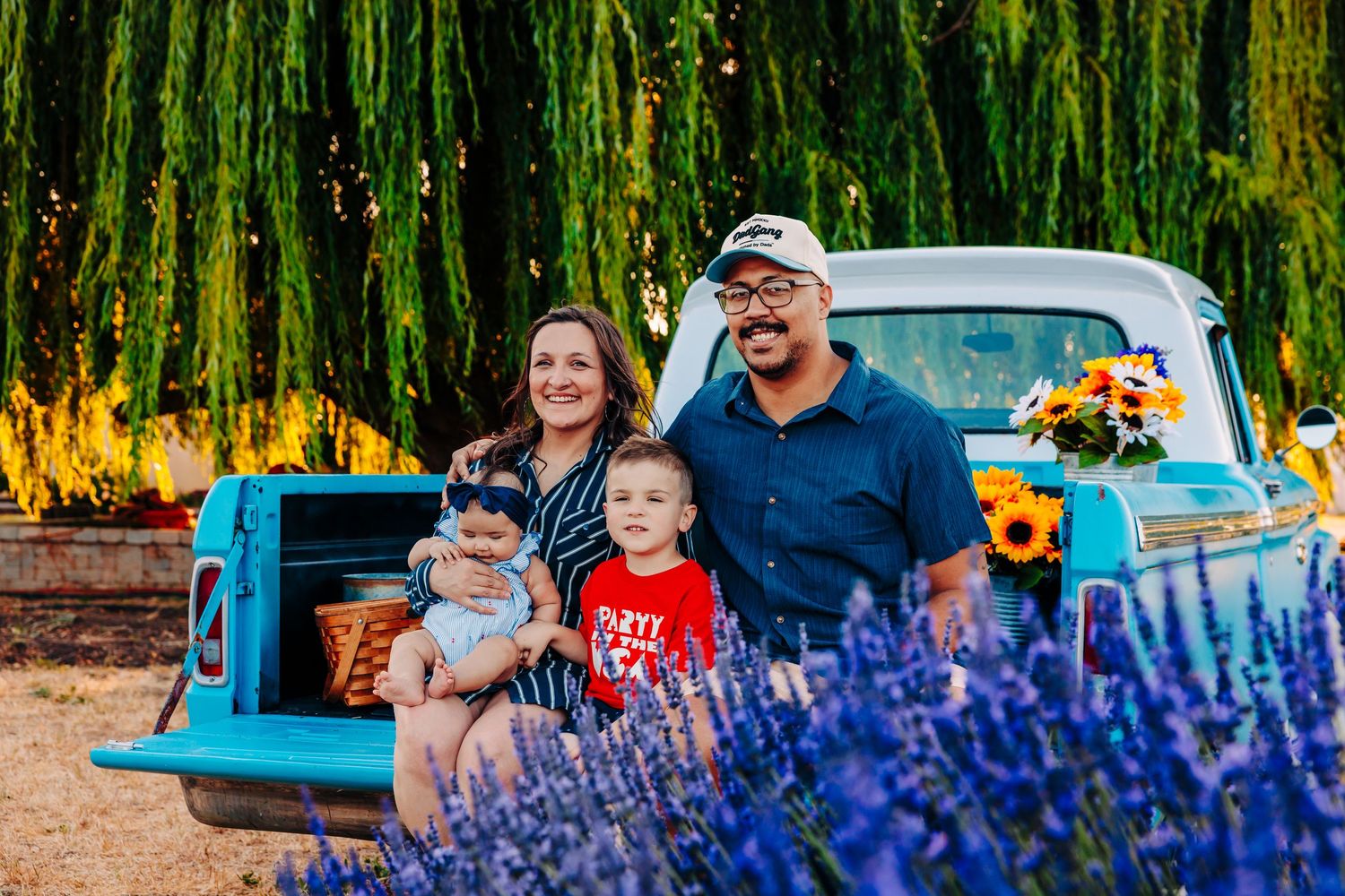 Vibrant purple lavender flowers bloom in the foreground with a classic turquoise car parked in the background.