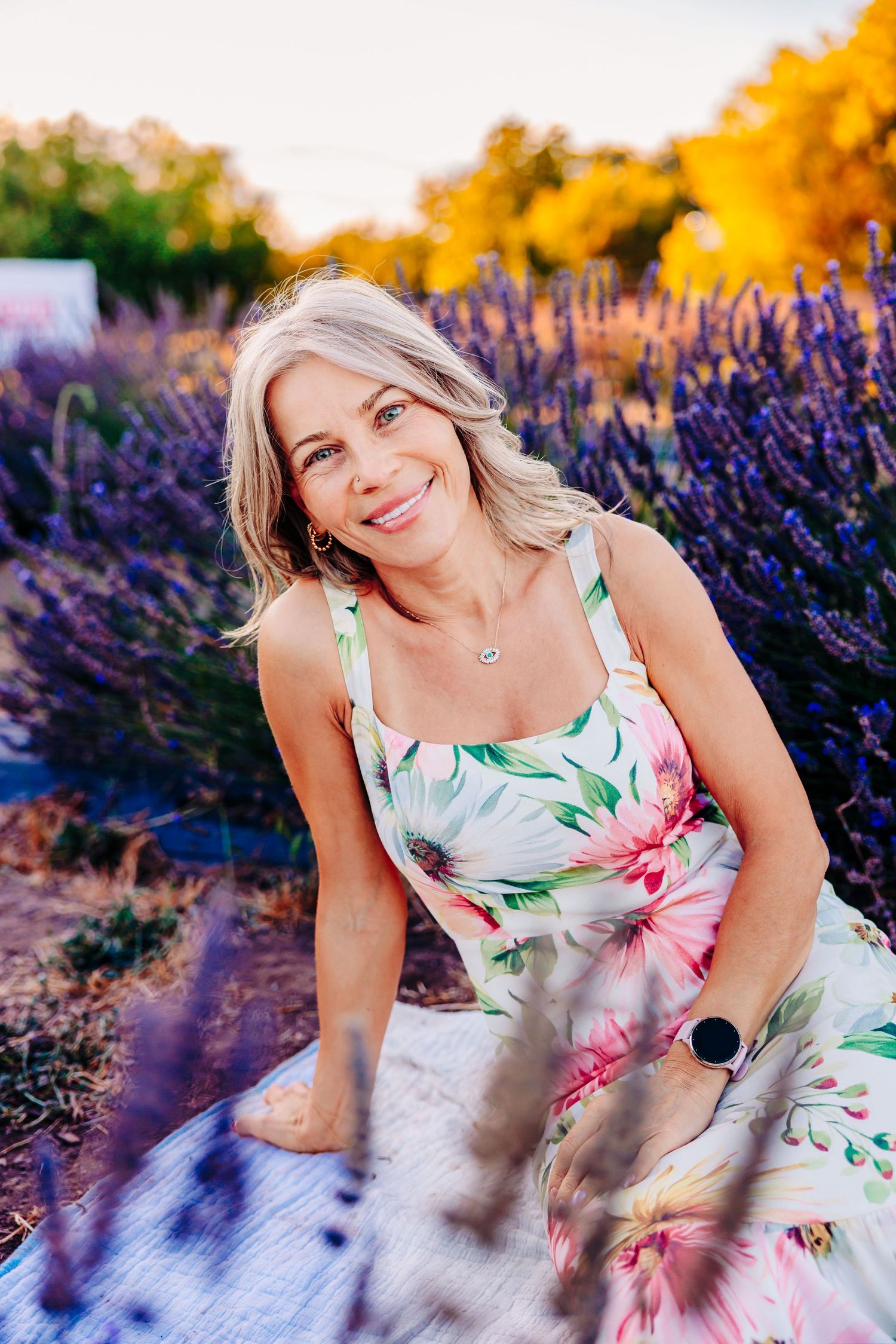 A floral sundress stands out against vibrant purple lavender fields during golden hour photography session.