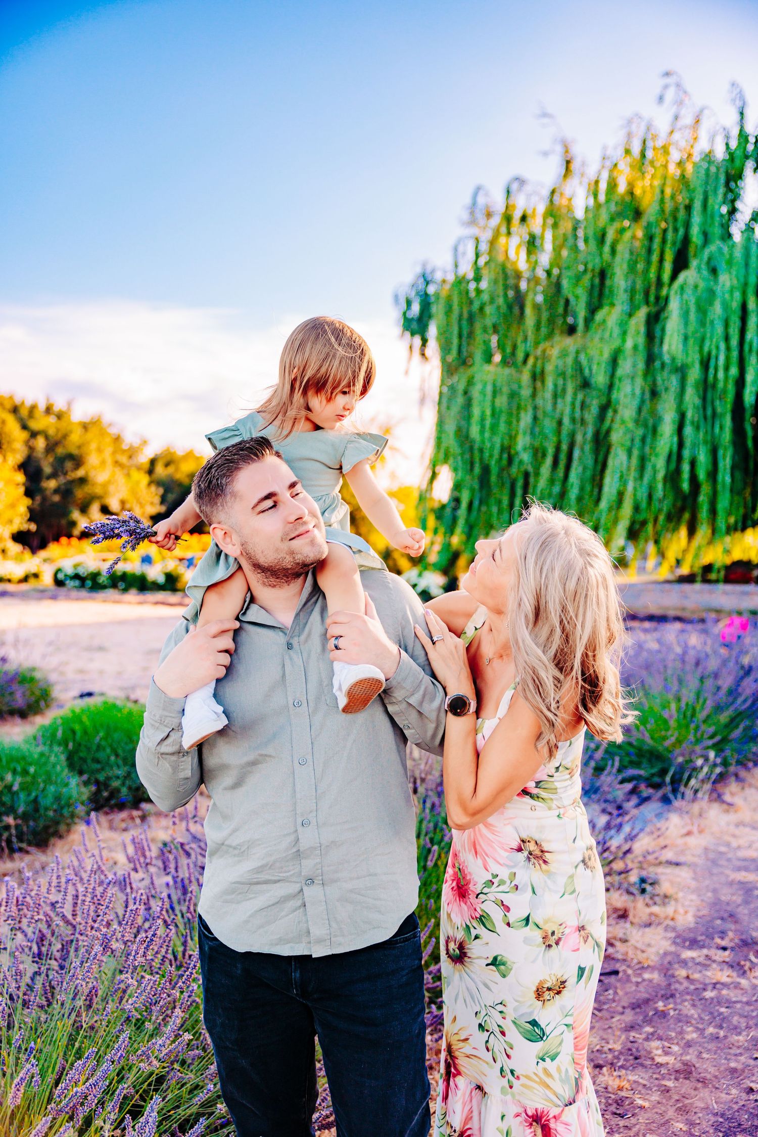 A couple shares playful moments together in a lavender field at sunset.