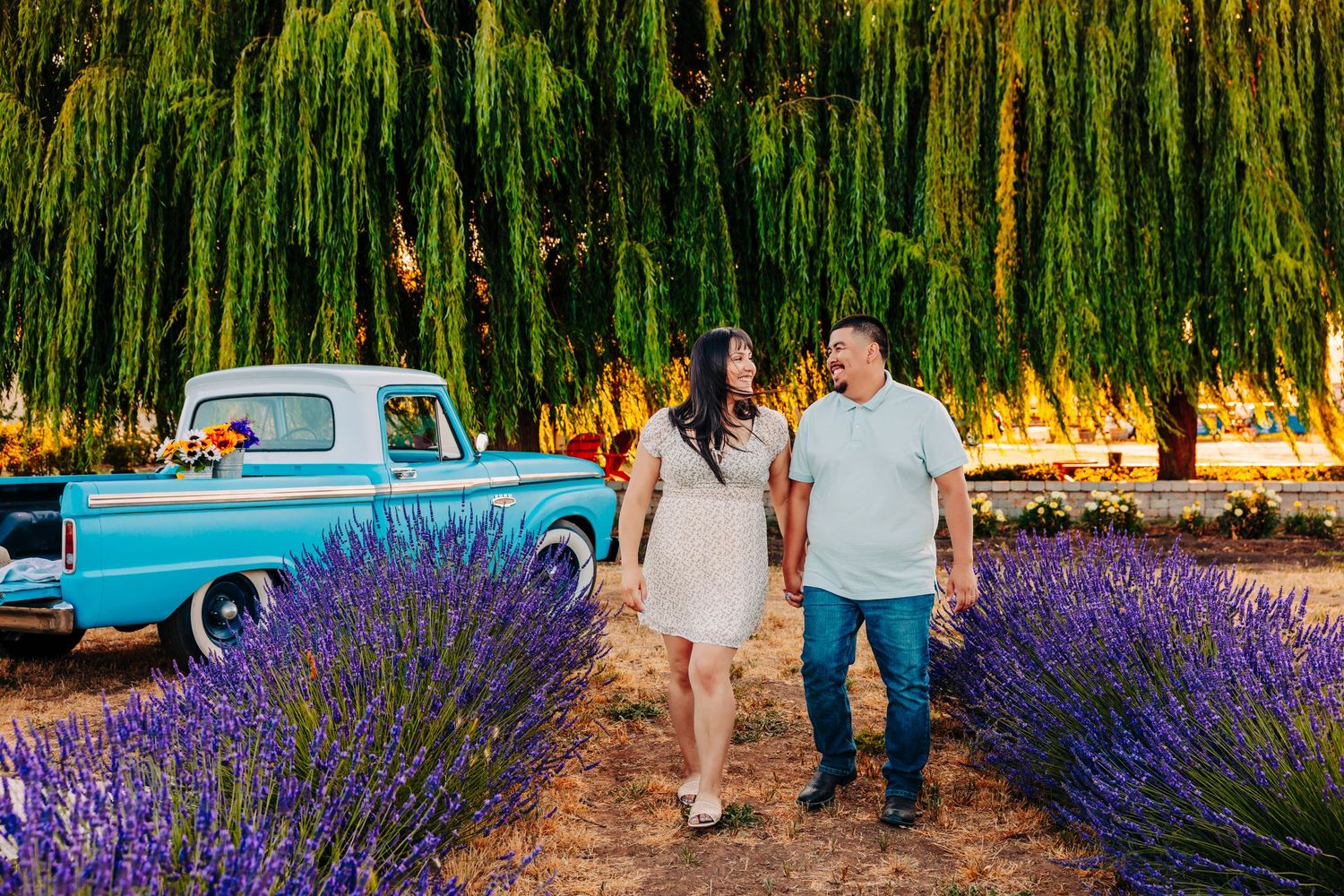 A candid family moment captured among blooming lavender with a classic turquoise automobile in the background.