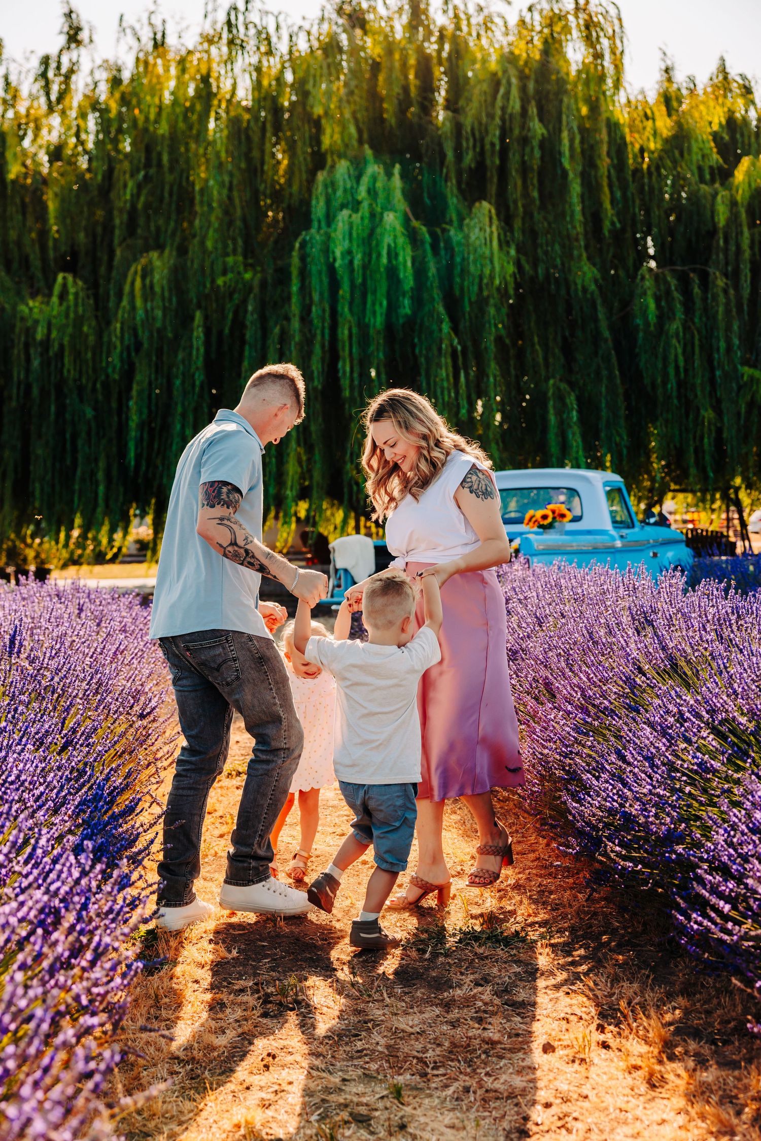 A family walks together through rows of blooming lavender at sunset, creating a series of candid moments in golden light.