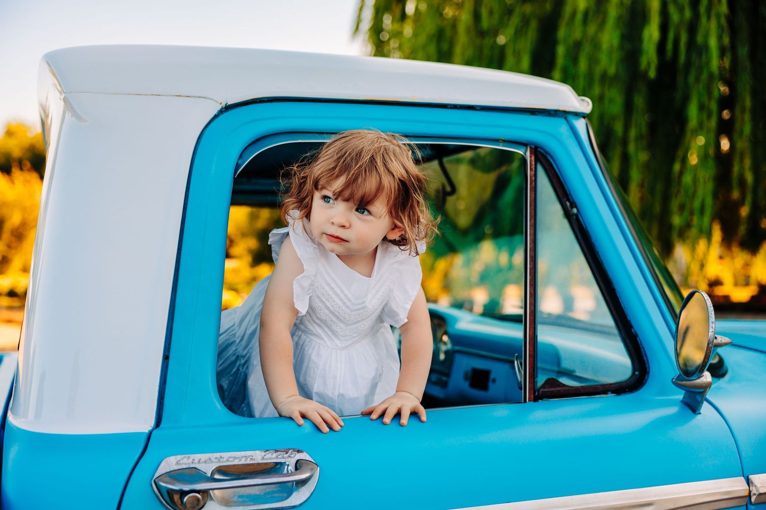 A bright turquoise vintage car parked near a lavender field on a sunny summer day.
