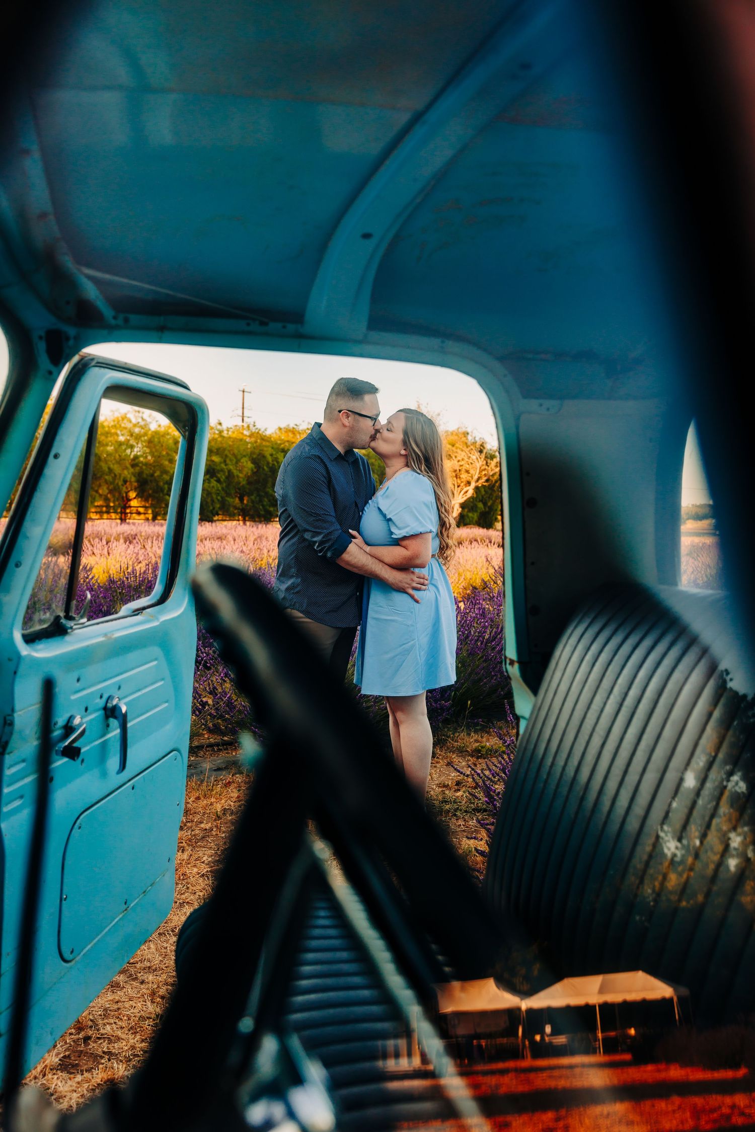 View through vintage truck windows showing interior seats and door panels with sunset lighting.