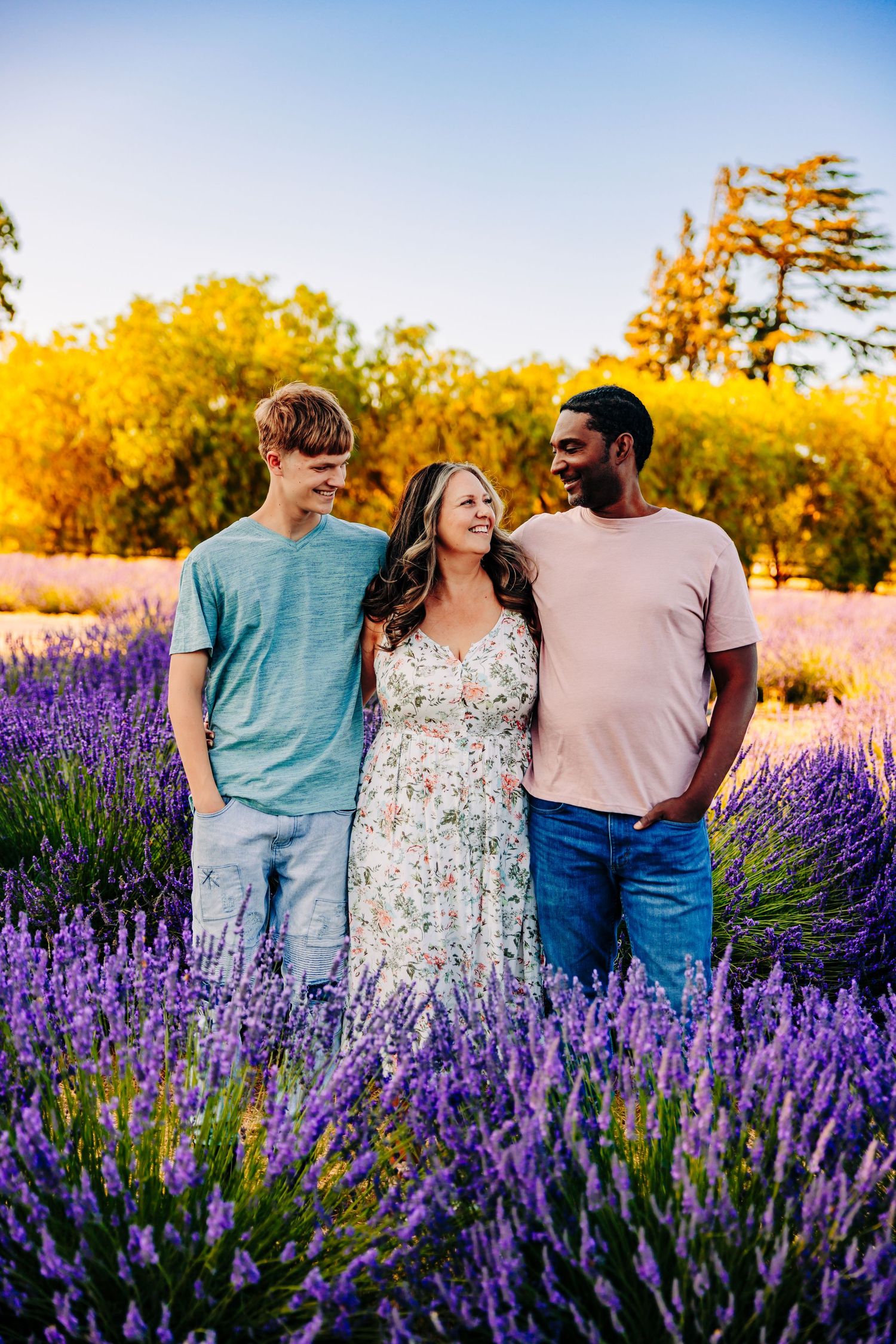 People share intimate moments while posing in a beautiful lavender field during golden hour.