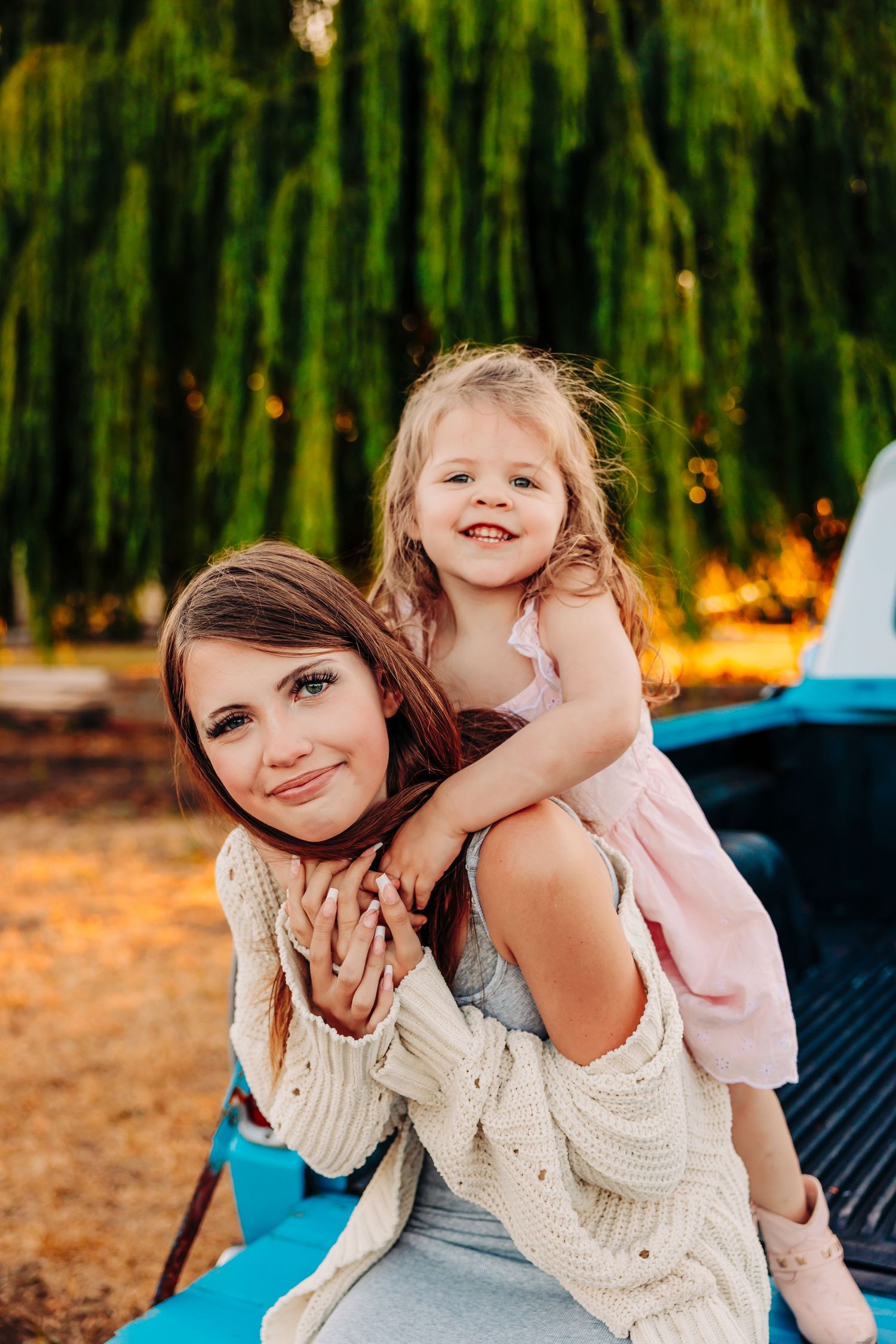 Mother and child share joyful moments together while sitting outdoors on a sunny day.