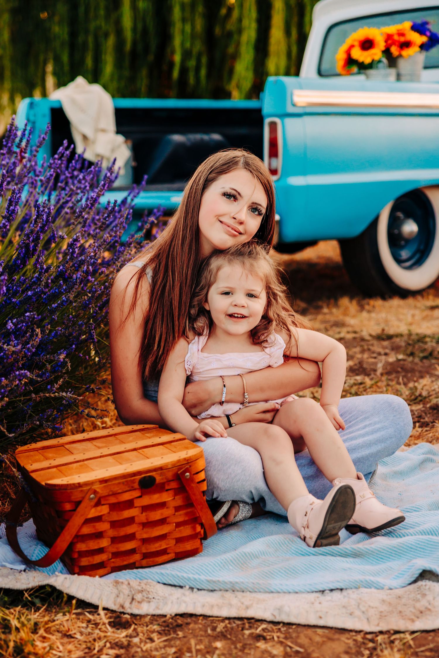 A picnic scene with a vintage turquoise car and purple lavender flowers in the background on a sunny day.