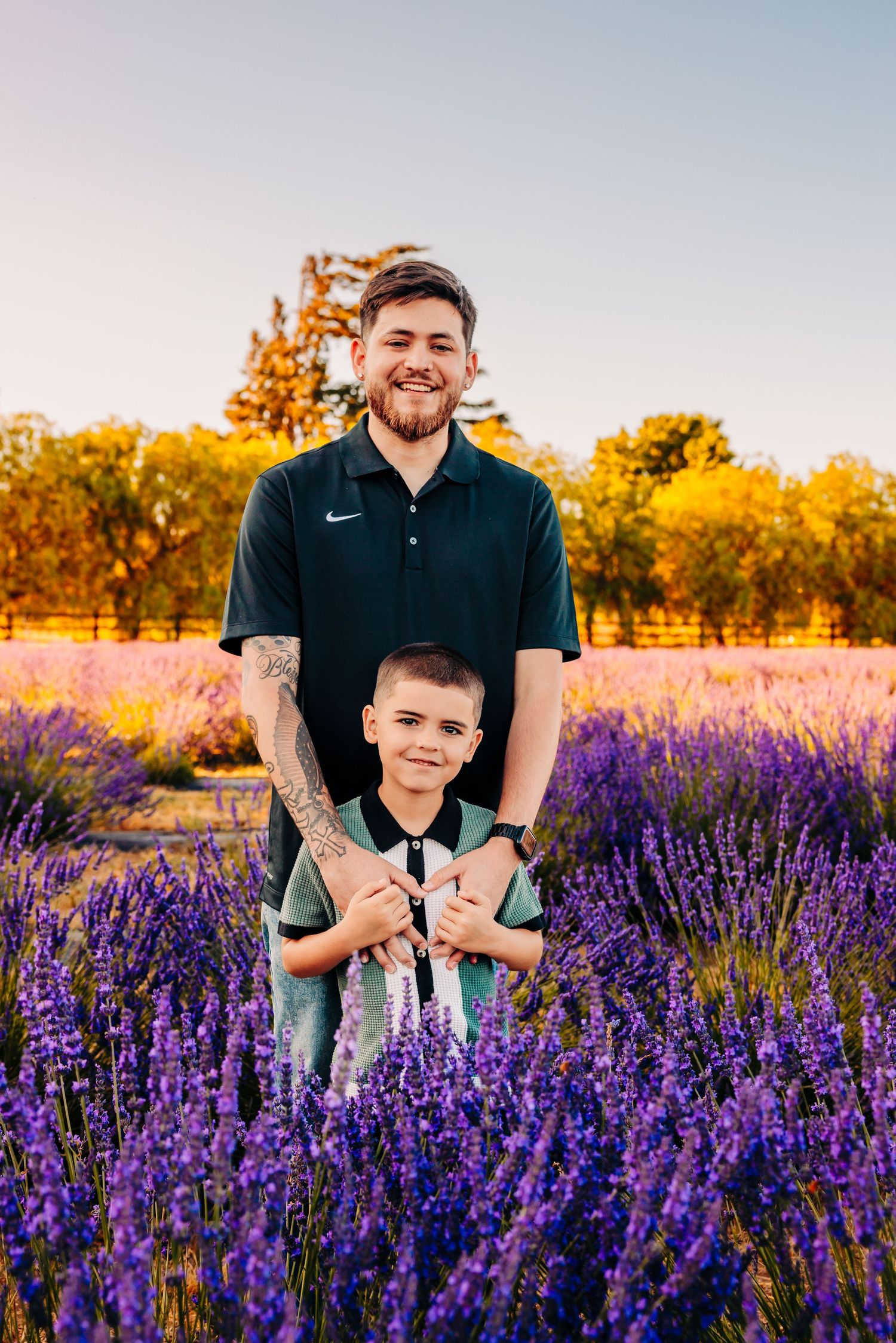 People stand together in a vibrant purple lavender field at sunset with golden light illuminating the scene.