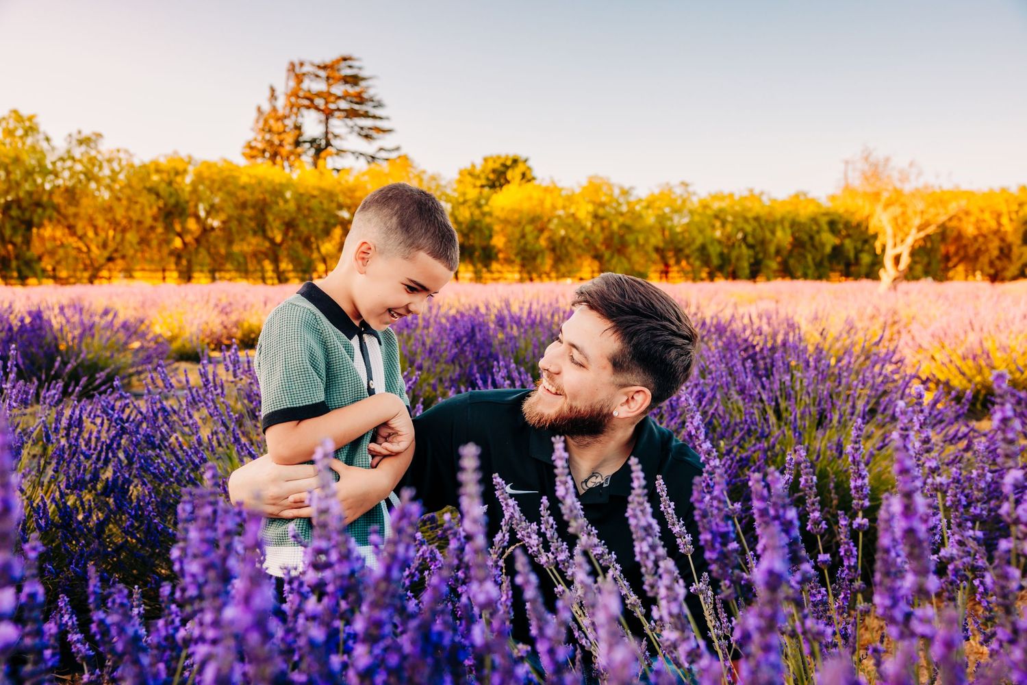 A couple shares a romantic moment in a vibrant purple lavender field at sunset.