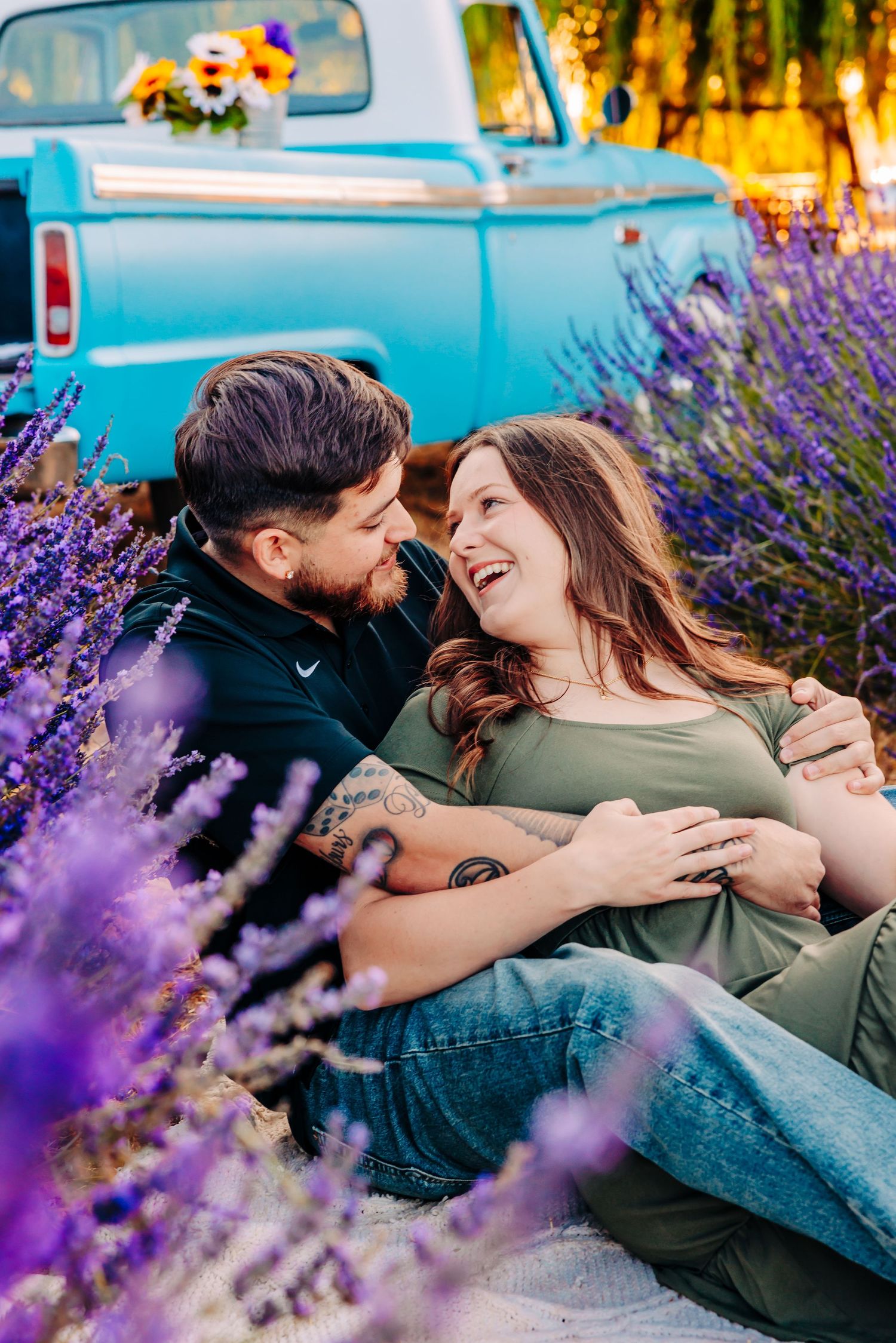 A romantic couple shares intimate moments among blooming purple lavender flowers on a sunny afternoon.
