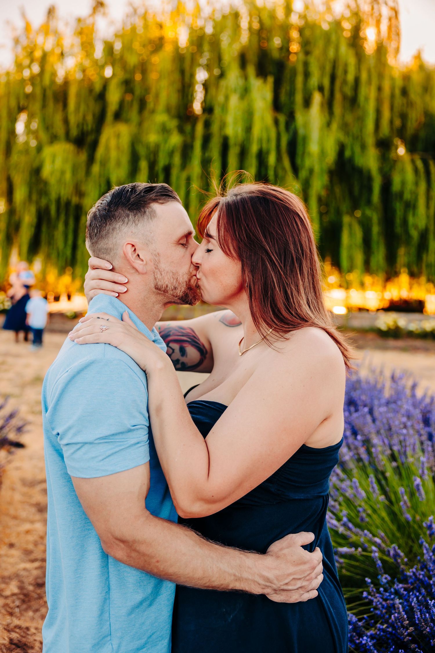 A couple shares intimate moments near blooming lavender fields during sunset.