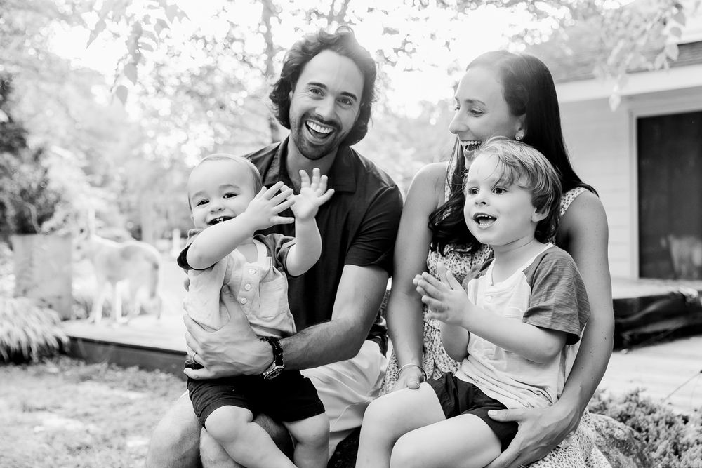 A black and white photo series showing joyful candid moments of family members laughing together outdoors.