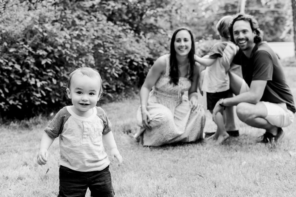 A collection of black and white family portraits showing tender moments outdoors.