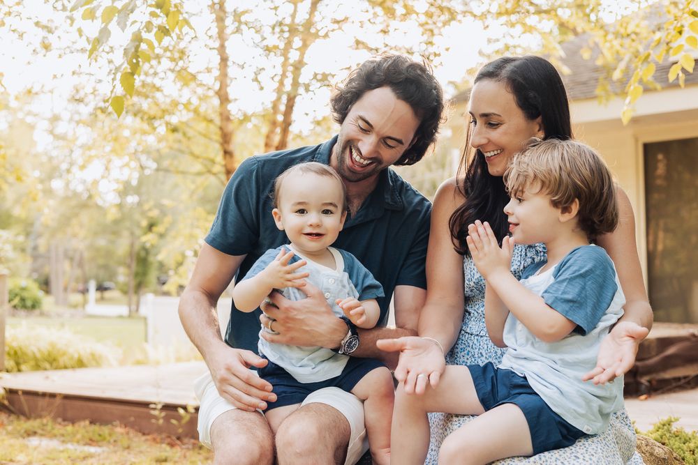 Family sharing joyful moments together outdoors during golden hour in a natural setting.