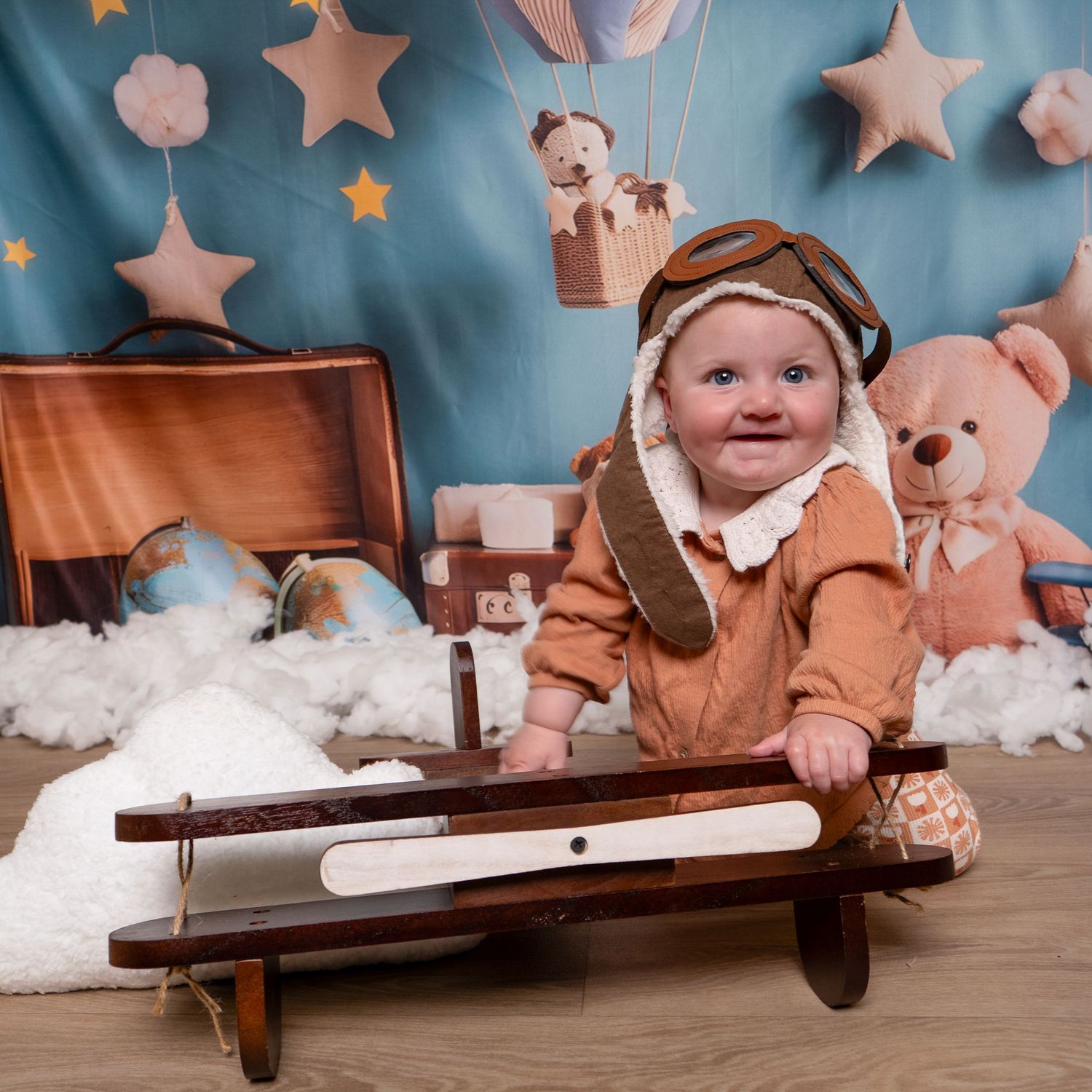 Rustic wooden bench setting with pink stars and soft decorative elements against a blue backdrop.