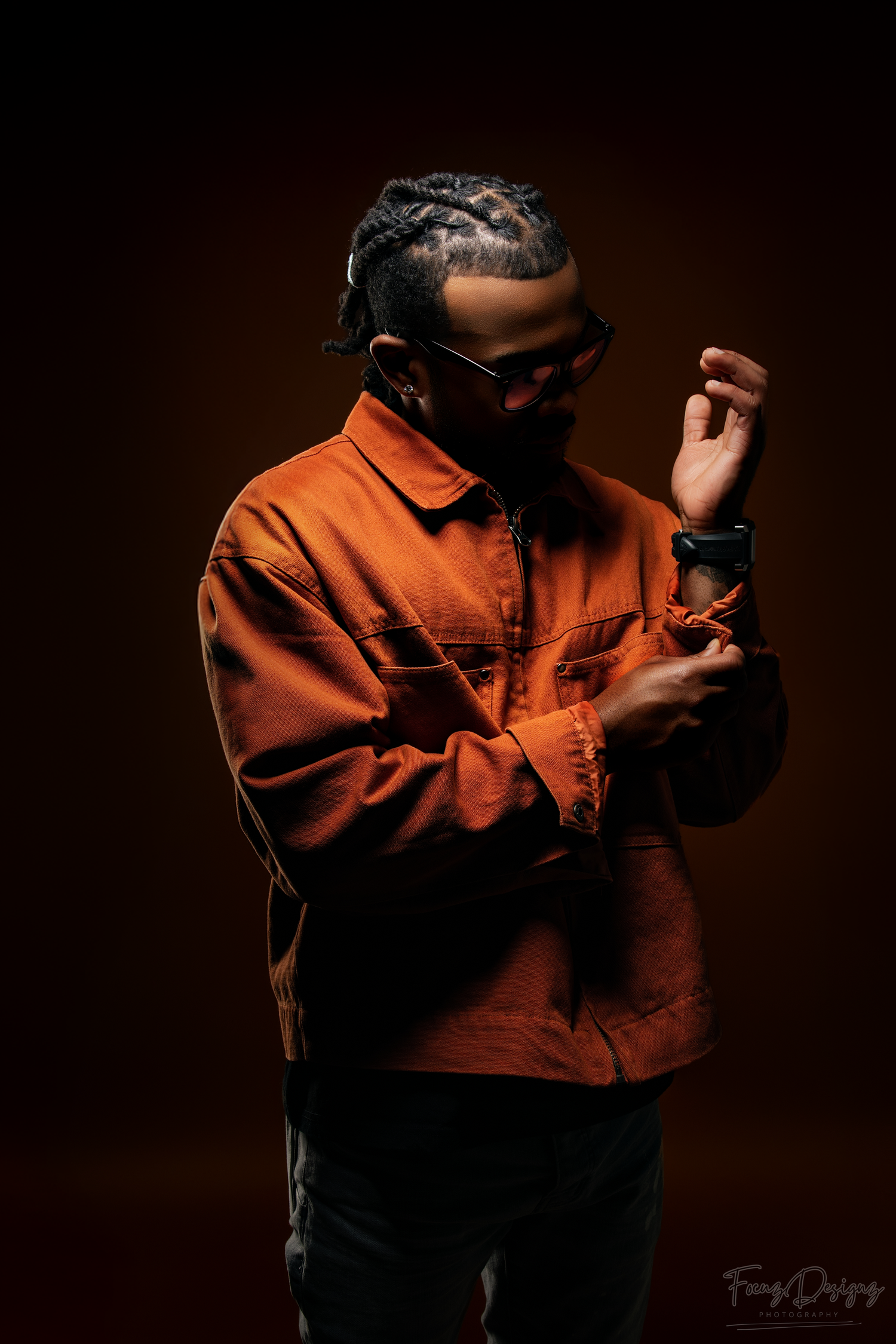 Person in orange jacket shown in dramatic lighting sequence against dark background creating moody artistic portraits.