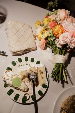 Wedding reception plates with elegant sushi rolls and floral arrangements in soft pink and peach tones.