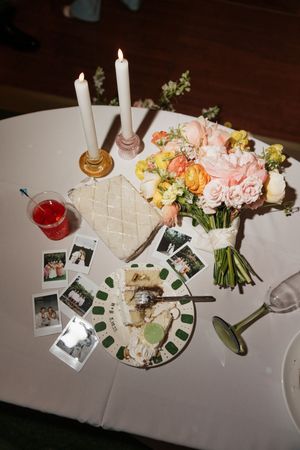 Wedding reception table decorated with pink flowers, candles and place settings.