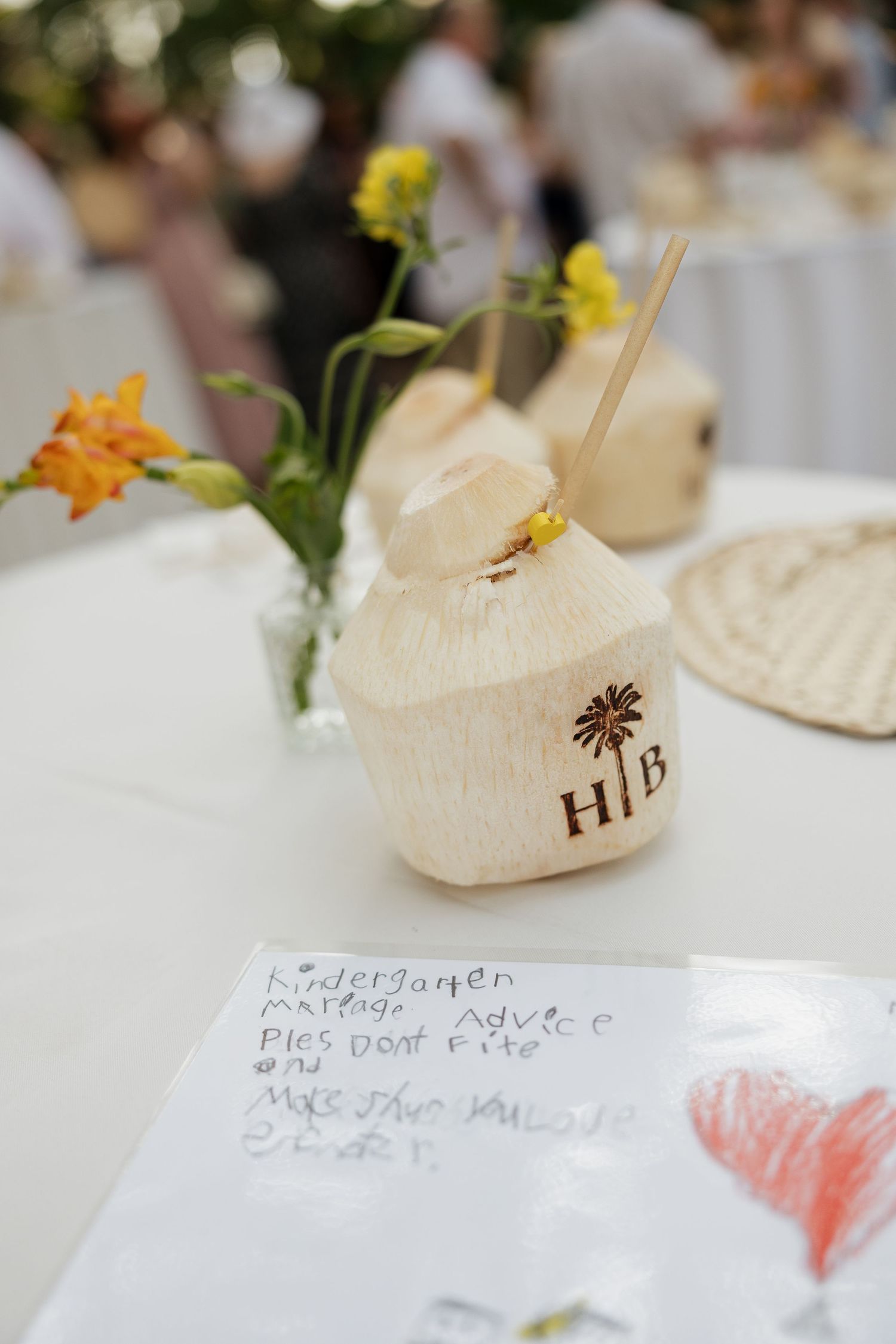 Wedding reception table details showing place cards and decorative elements in cream and yellow tones.
