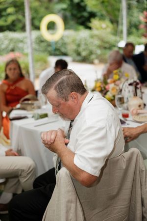 Guests seated at outdoor tables during a wedding reception.