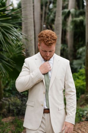 Emotional wedding moment captured in a lush tropical garden setting.