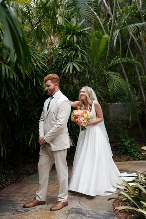 Tropical garden wedding photoshoot with palm trees and lush greenery.