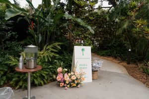 Outdoor wedding venue path with decorative signs and tropical landscaping.