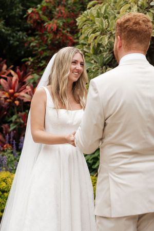 Bride and groom share a romantic moment during their first dance in a garden setting.
