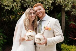 A couple shares an intimate moment while holding matching 'Mr' and 'Mrs' coffee mugs.