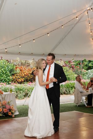 A romantic wedding dance sequence under a white tent with string lights and floral decorations.