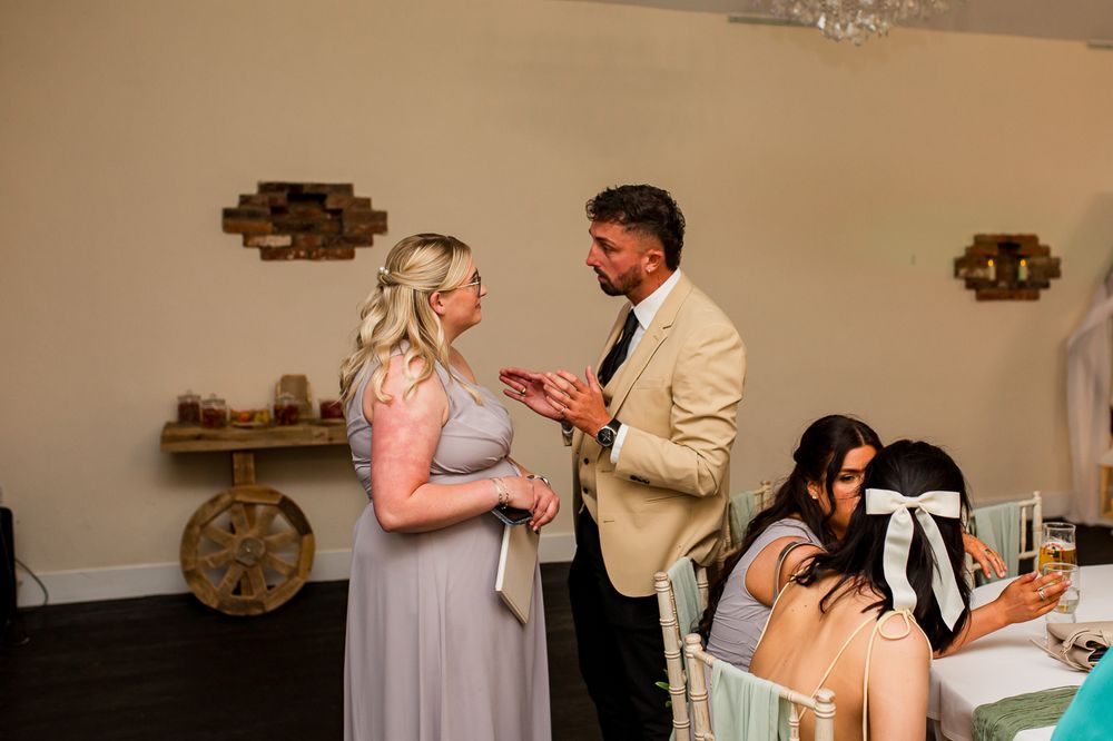 Wedding reception scene with guests and decorative elements.