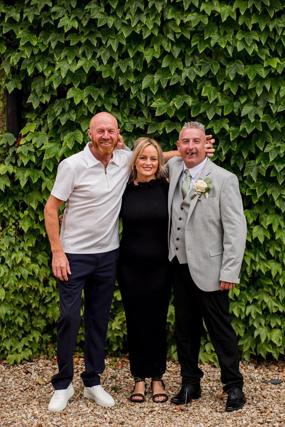 Casual group portrait in front of an ivy-covered wall.