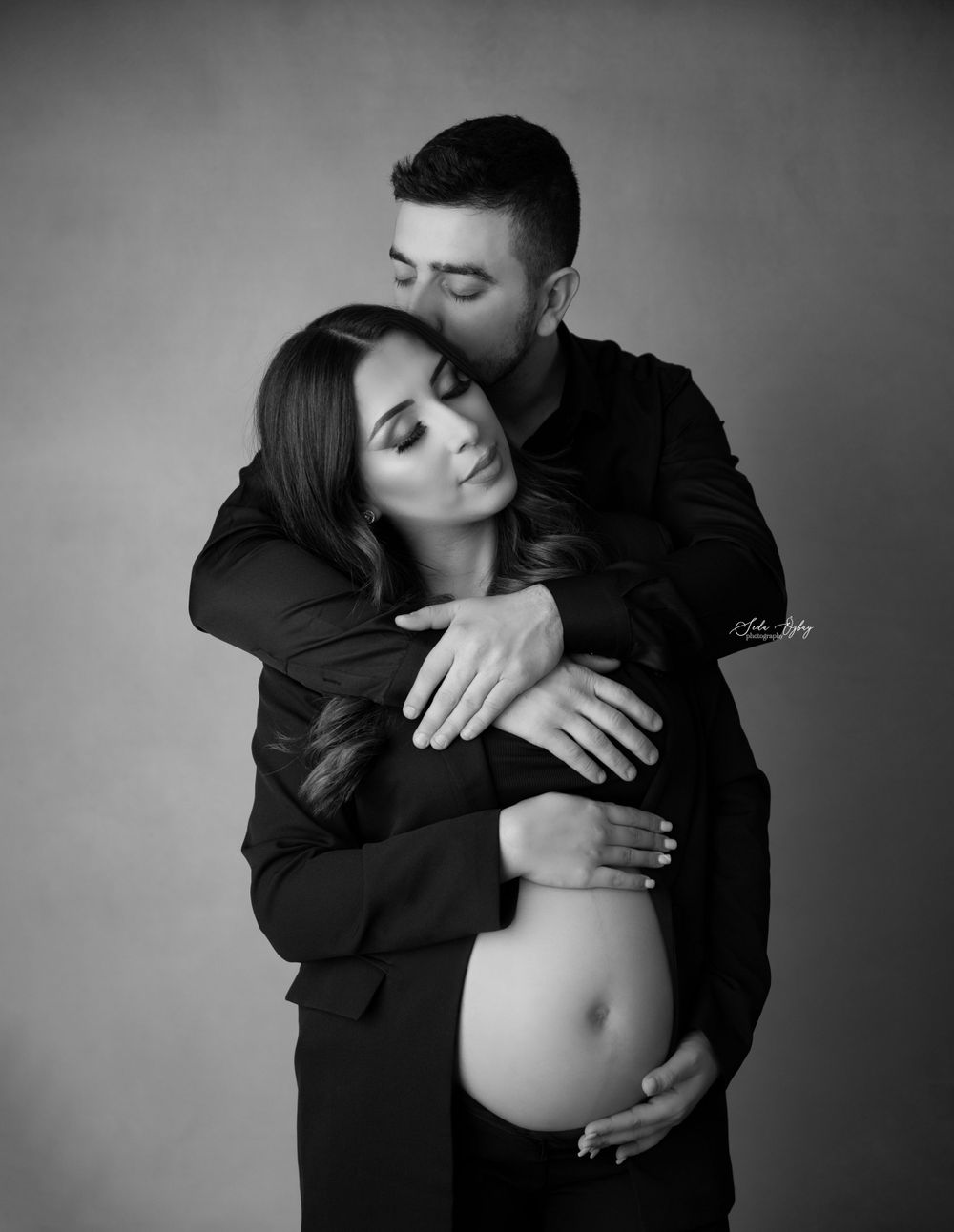 An intimate black and white maternity photo showing a tender embrace.