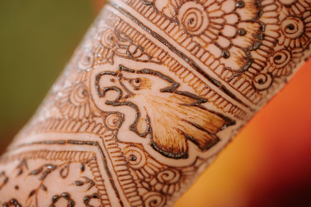 Close-up view of intricate henna mehndi designs featuring swirls and floral patterns on hands.