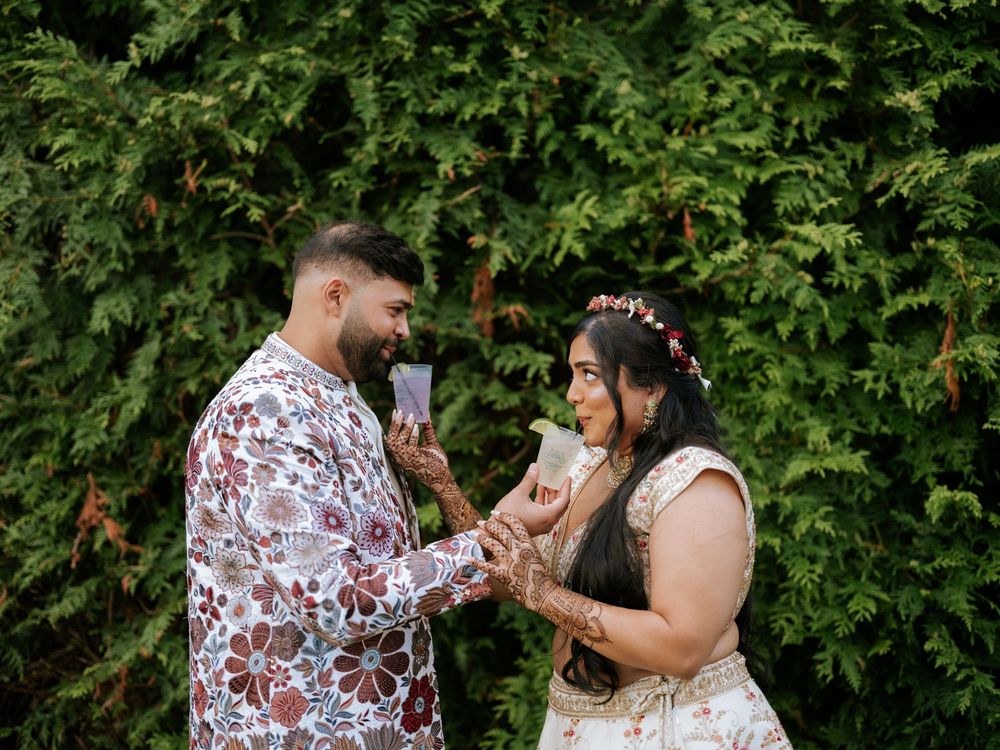 A couple shares joyful moments together in a lush green garden setting during a romantic outdoor photoshoot.