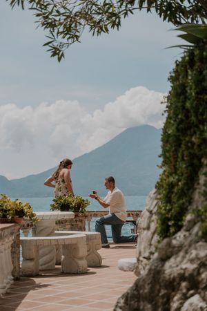 Scenic Mediterranean coastal terrace with stone balustrade overlooking mountains and sea on a sunny summer day.