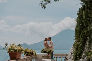 Scenic mountain wedding ceremony setup with white chairs and floral arrangements overlooking a serene lake.