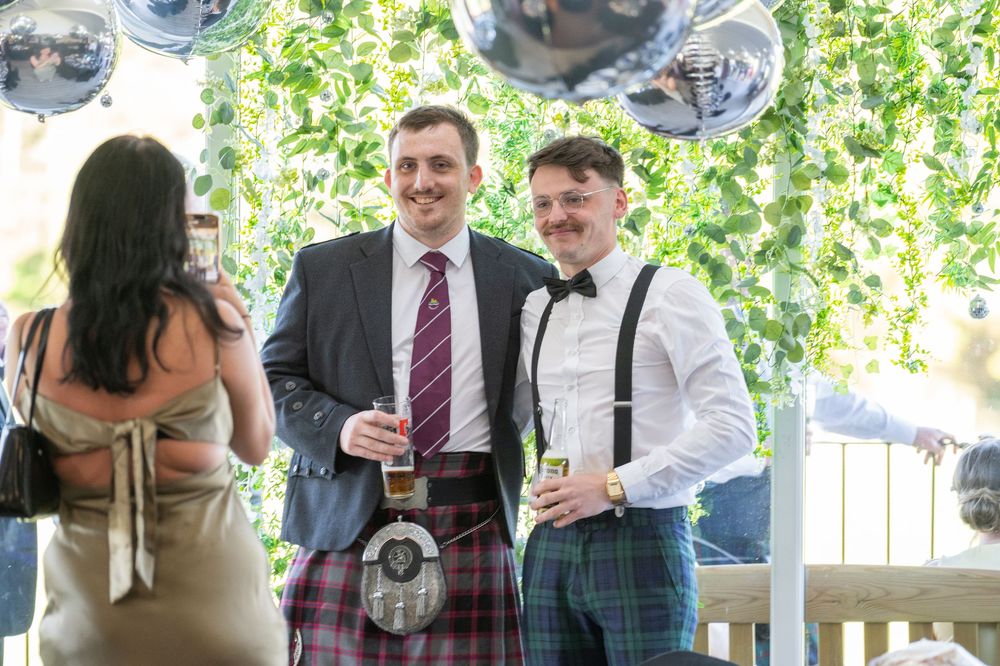Wedding celebration scene with disco balls and greenery decorations.